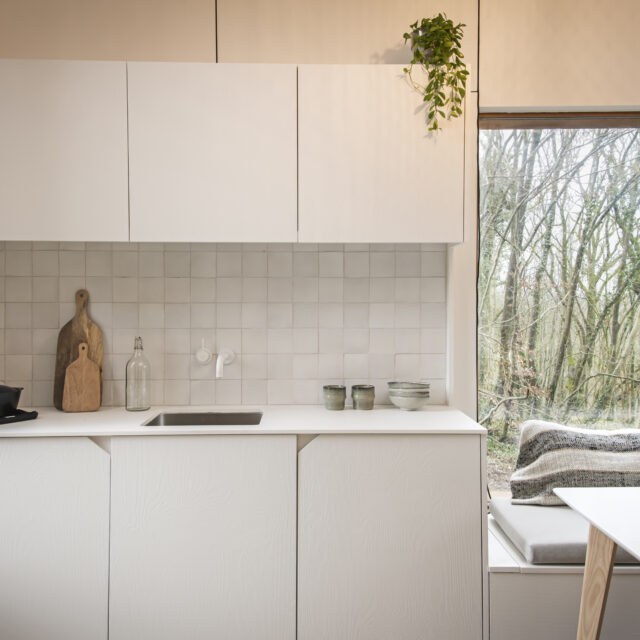 outen woonunit met binnenschrijnwerk met witte keuken en witte keukentafel