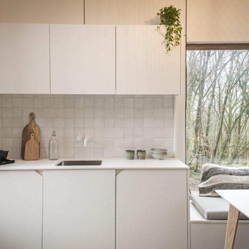 outen woonunit met binnenschrijnwerk met witte keuken en witte keukentafel